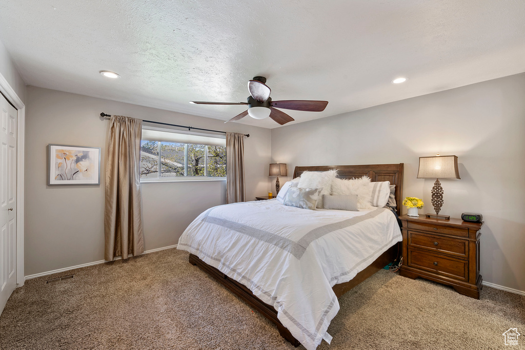Bedroom featuring a closet, ceiling fan, and dark carpet