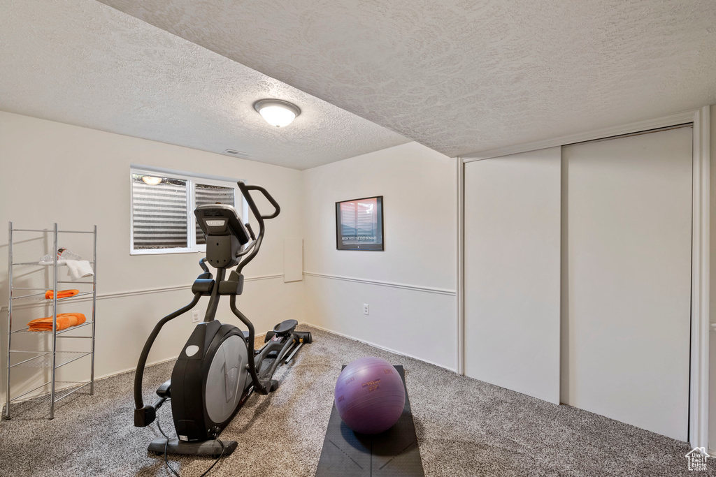 Workout area featuring carpet and a textured ceiling
