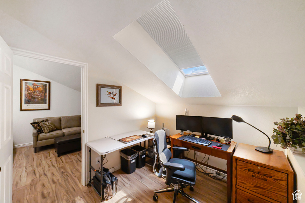 Office with a skylight and light hardwood / wood-style floors