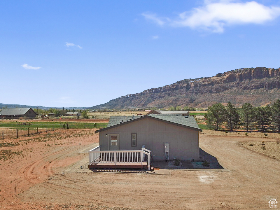 Rear view of property with a rural view and a deck with mountain view