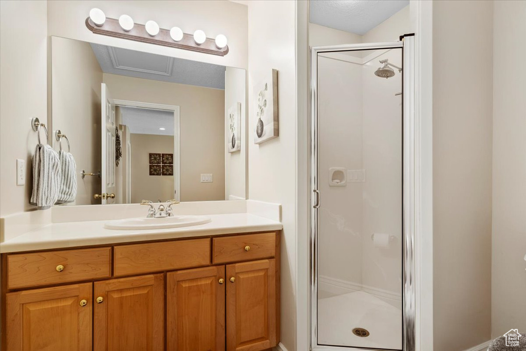 Bathroom with vanity with extensive cabinet space and a shower with shower door