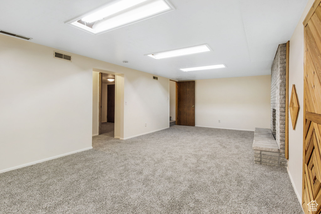 Empty room featuring wooden walls and light colored carpet