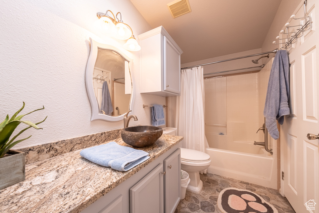 Full bathroom with tile flooring, vanity, shower / bath combo, and toilet