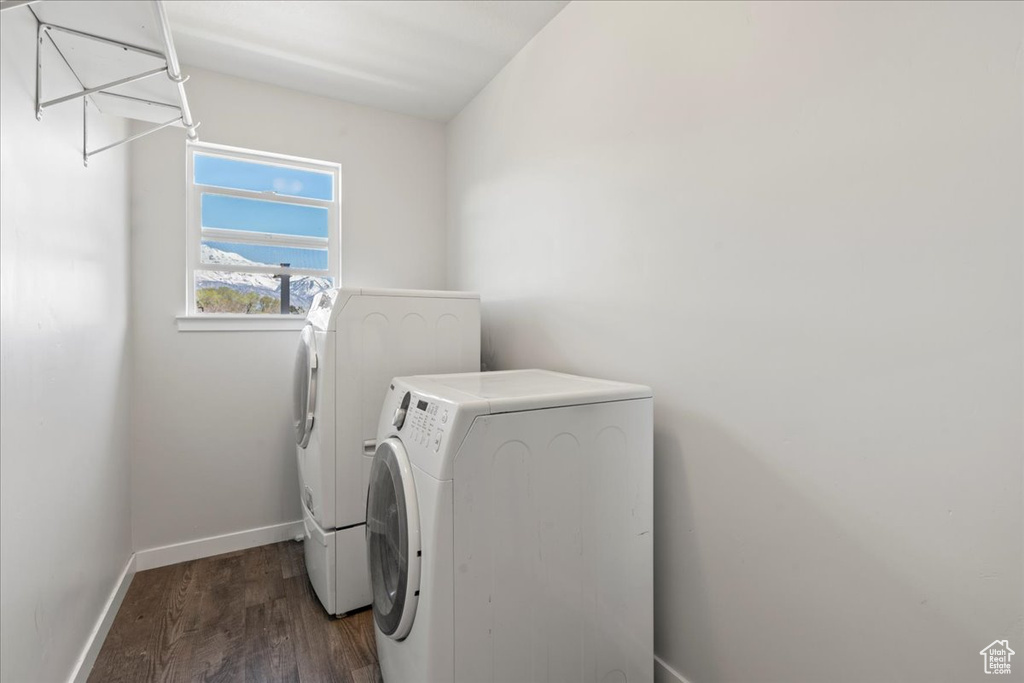 Laundry area with dark wood-type flooring and washing machine and clothes dryer