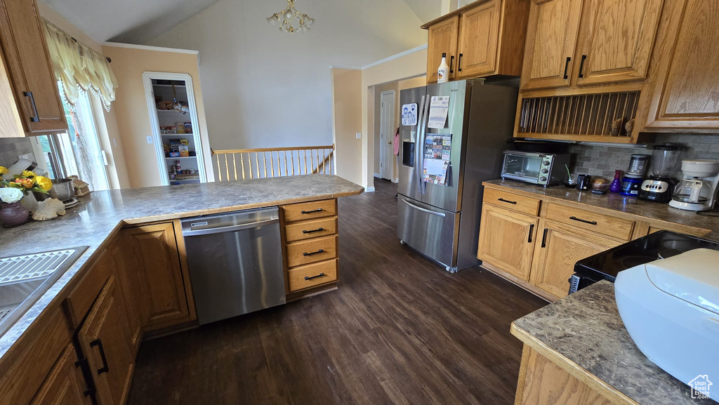 Kitchen featuring backsplash, dark hardwood / wood-style flooring, crown molding, a chandelier, and stainless steel appliances