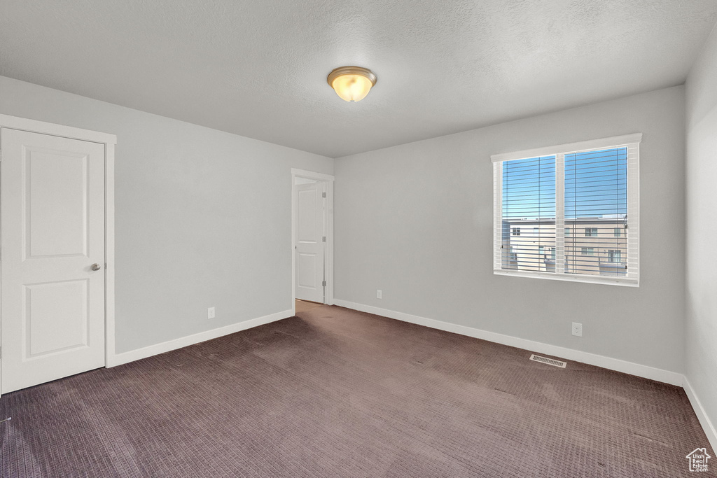 Empty room with dark colored carpet