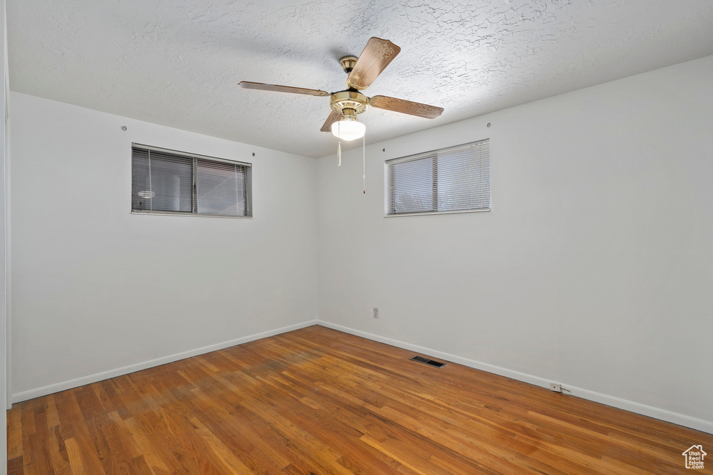 Spare room with ceiling fan, dark hardwood / wood-style floors, and a textured ceiling