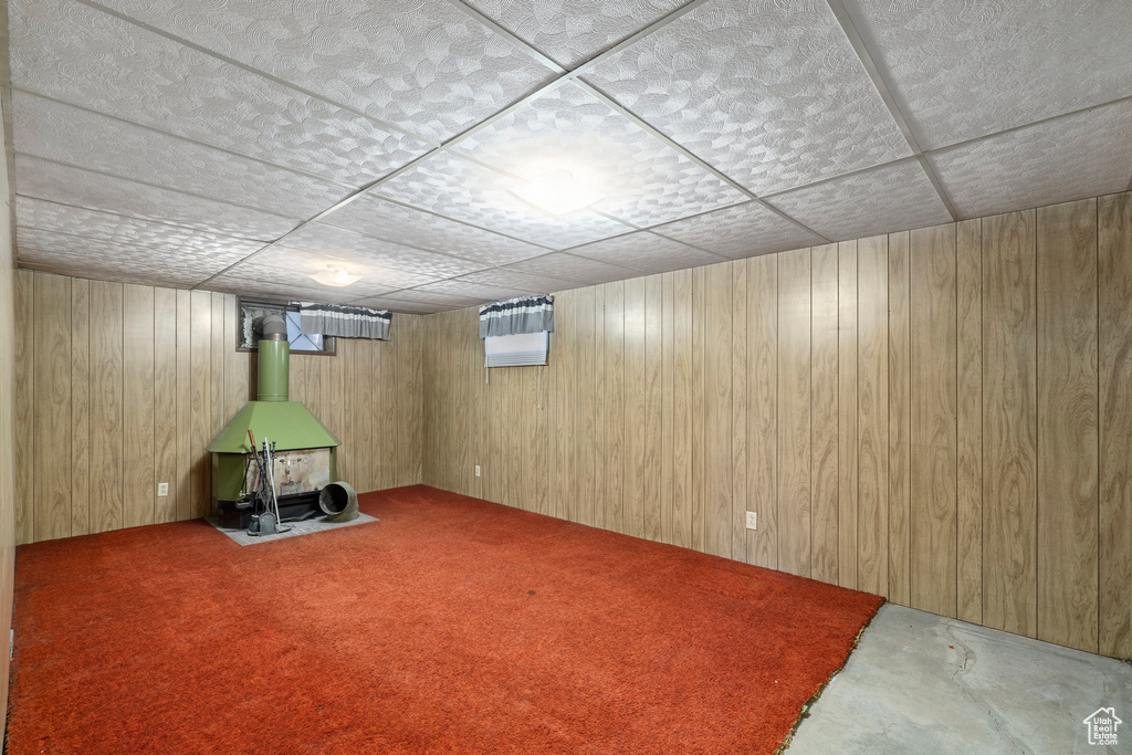 Basement featuring a paneled ceiling and wooden walls