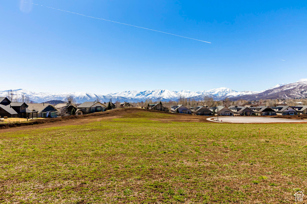 View of green lawn with a residential view and a mountain view