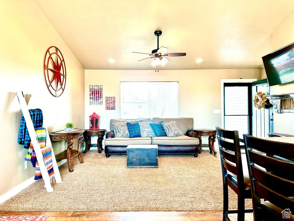 Living room with light hardwood / wood-style floors and ceiling fan