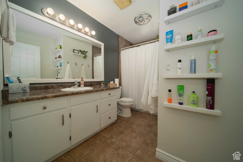 Bathroom featuring toilet, tile flooring, and vanity