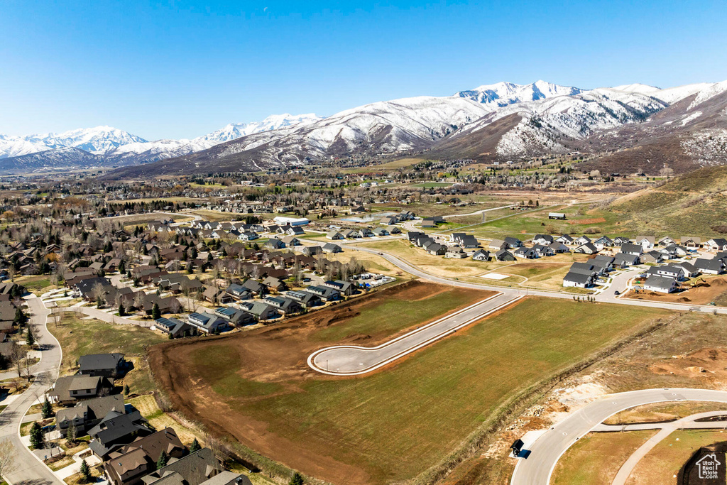 Aerial view of property's location featuring a mountain backdrop and nearby suburban area