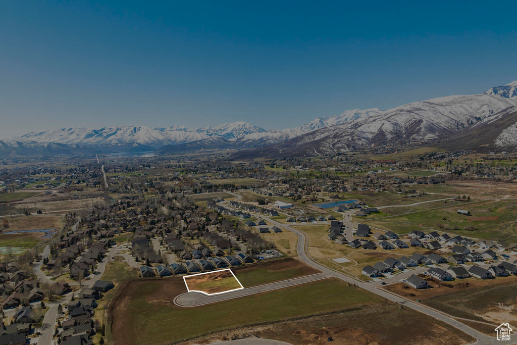 Aerial view of property's location featuring mountains, nearby suburban area, and property parcel outlined