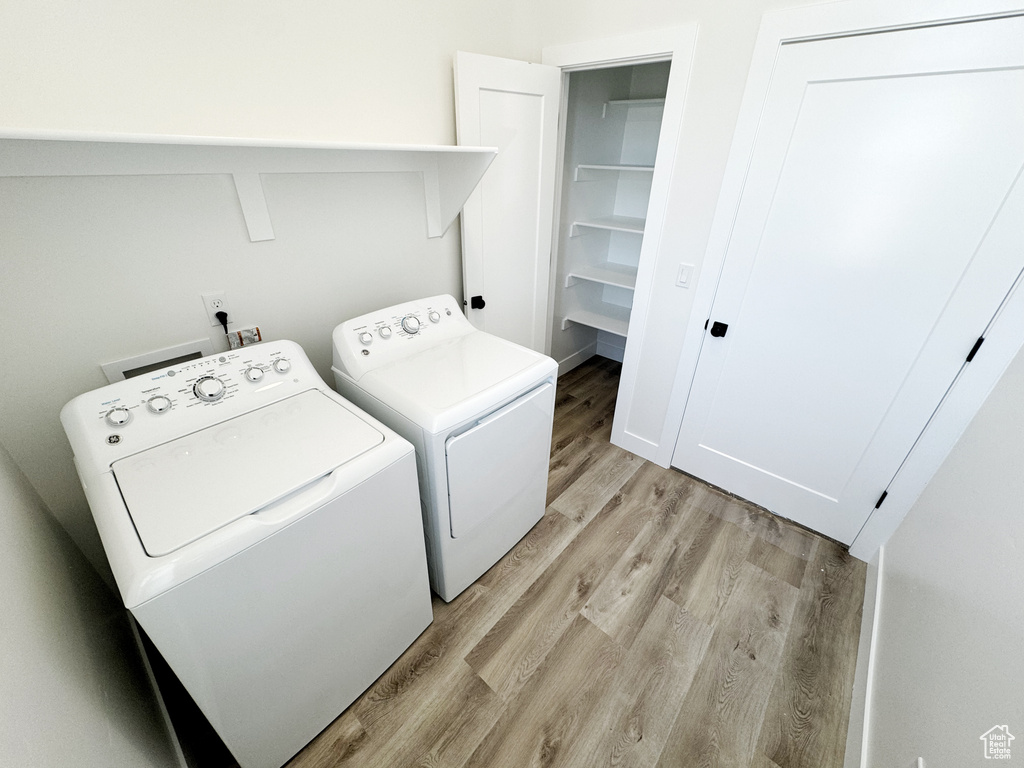 Clothes washing area featuring separate washer and dryer, light wood-type flooring, and washer hookup