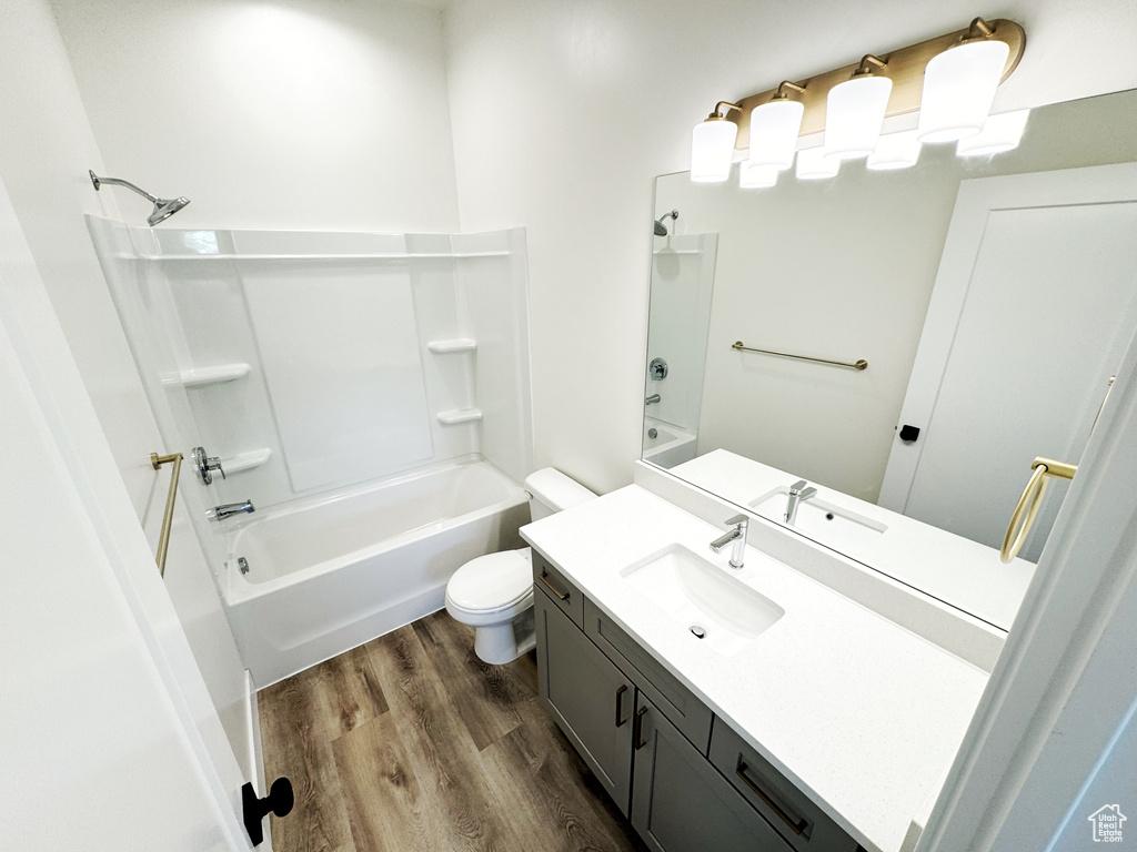 Full bathroom featuring bathtub / shower combination, hardwood / wood-style flooring, toilet, and large vanity