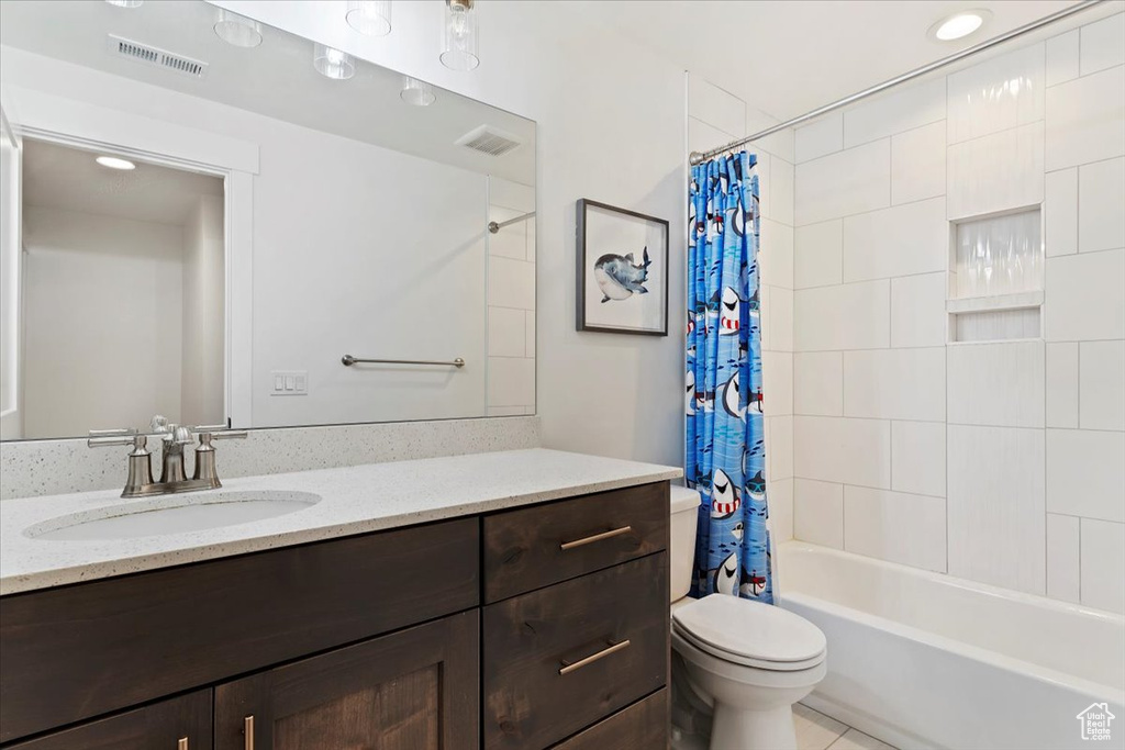 Full bathroom featuring toilet, tile floors, vanity, and shower / tub combo with curtain