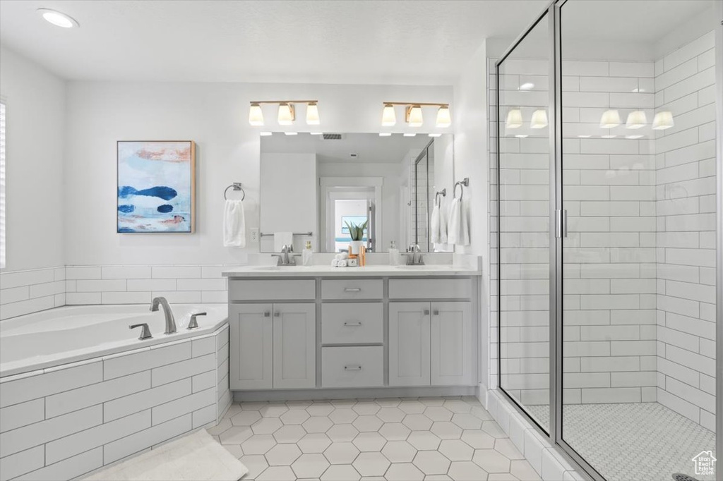 Bathroom featuring plus walk in shower, tile floors, and double vanity