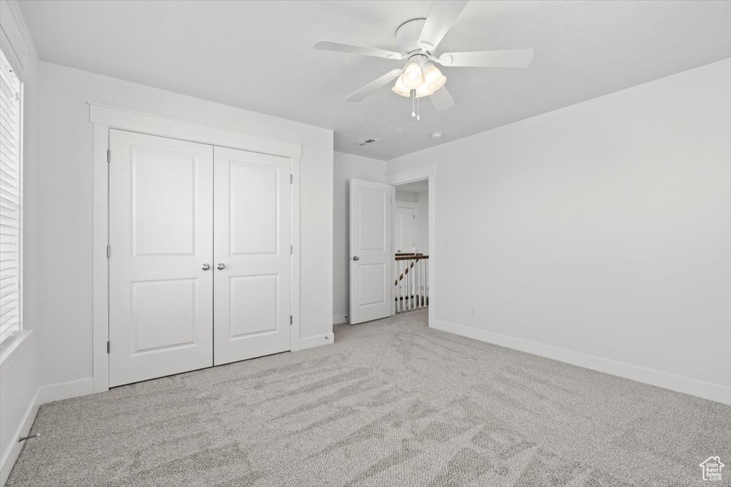 Unfurnished bedroom with a closet, light carpet, and ceiling fan