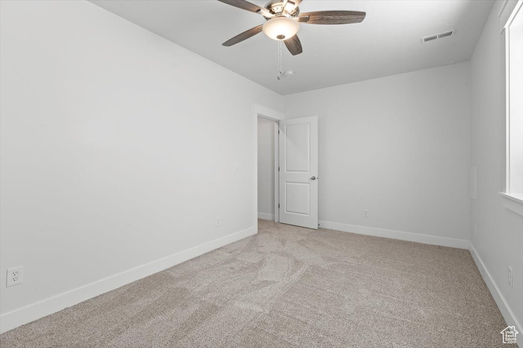 Unfurnished room with light colored carpet and ceiling fan