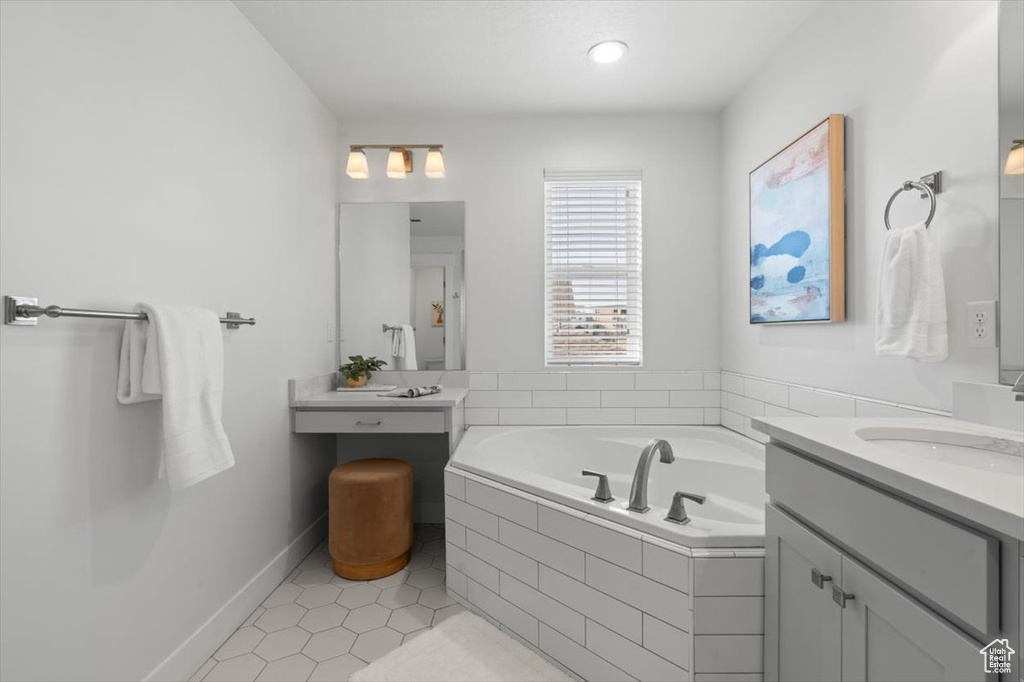 Bathroom featuring tiled tub, oversized vanity, and tile floors