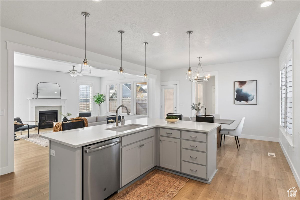 Kitchen featuring decorative light fixtures, light hardwood / wood-style floors, dishwasher, and gray cabinets