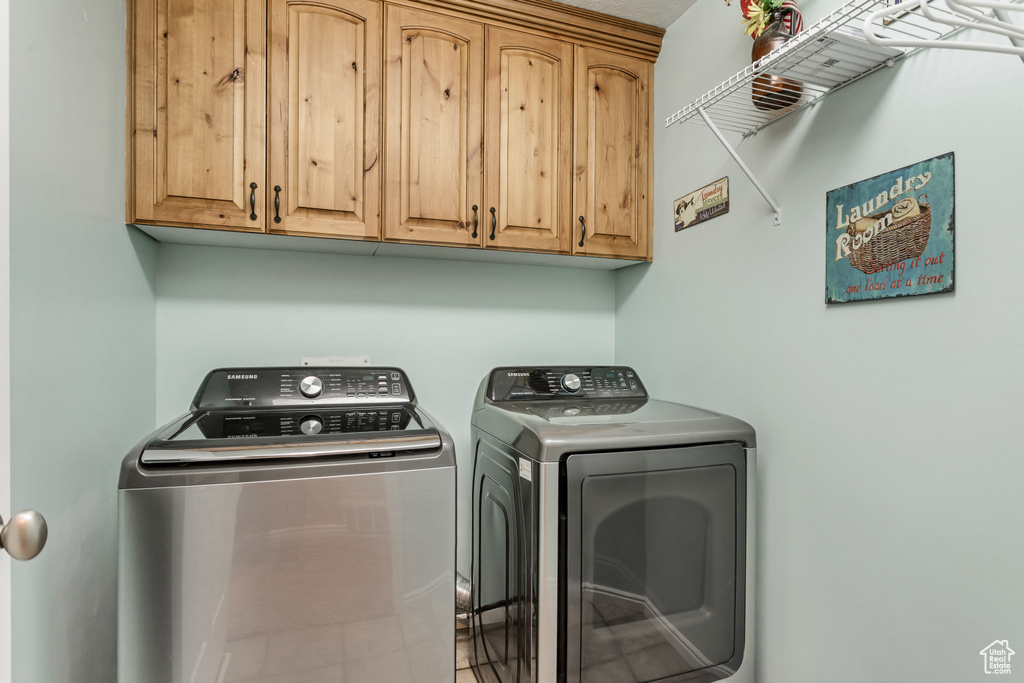 Washroom featuring cabinets and separate washer and dryer