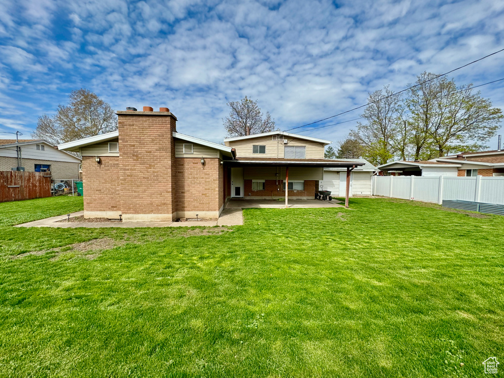 Rear view of house featuring a yard and a patio