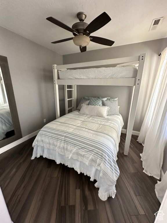 Bedroom with ceiling fan and dark hardwood / wood-style flooring