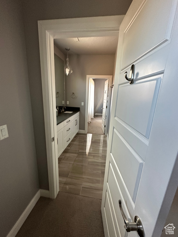 Hallway with sink and dark tile flooring