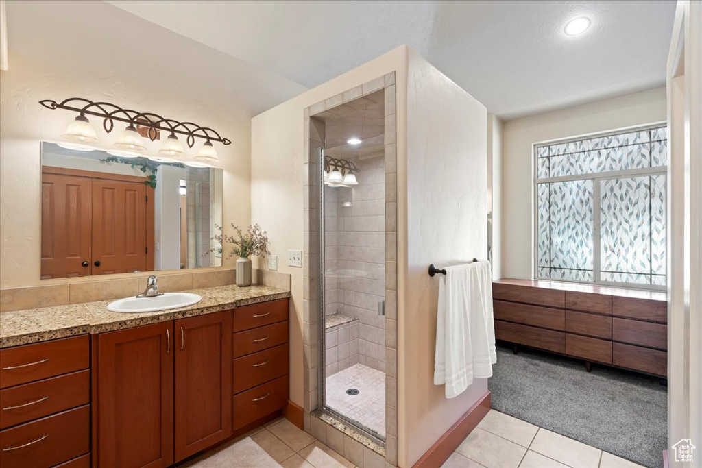 Bathroom with vanity, an enclosed shower, and tile floors