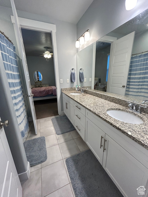 Bathroom featuring dual sinks, oversized vanity, tile floors, and ceiling fan