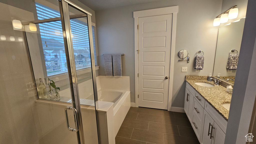Bathroom featuring tile flooring, double sink vanity, and plus walk in shower
