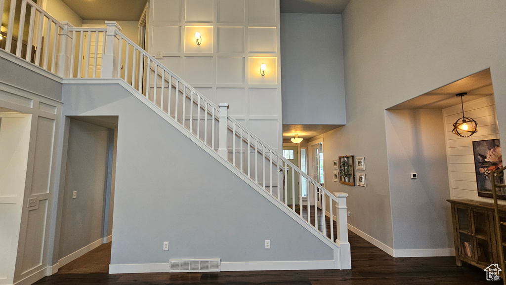 Stairway featuring a high ceiling and dark hardwood / wood-style floors