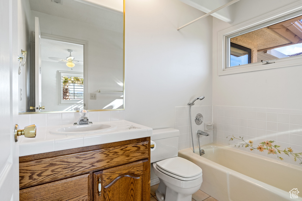 Full bathroom featuring oversized vanity, tile flooring, tub / shower combination, toilet, and ceiling fan