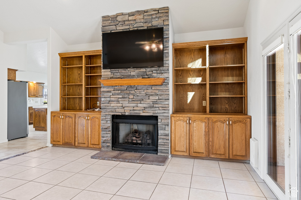 Unfurnished living room with a fireplace and light tile floors