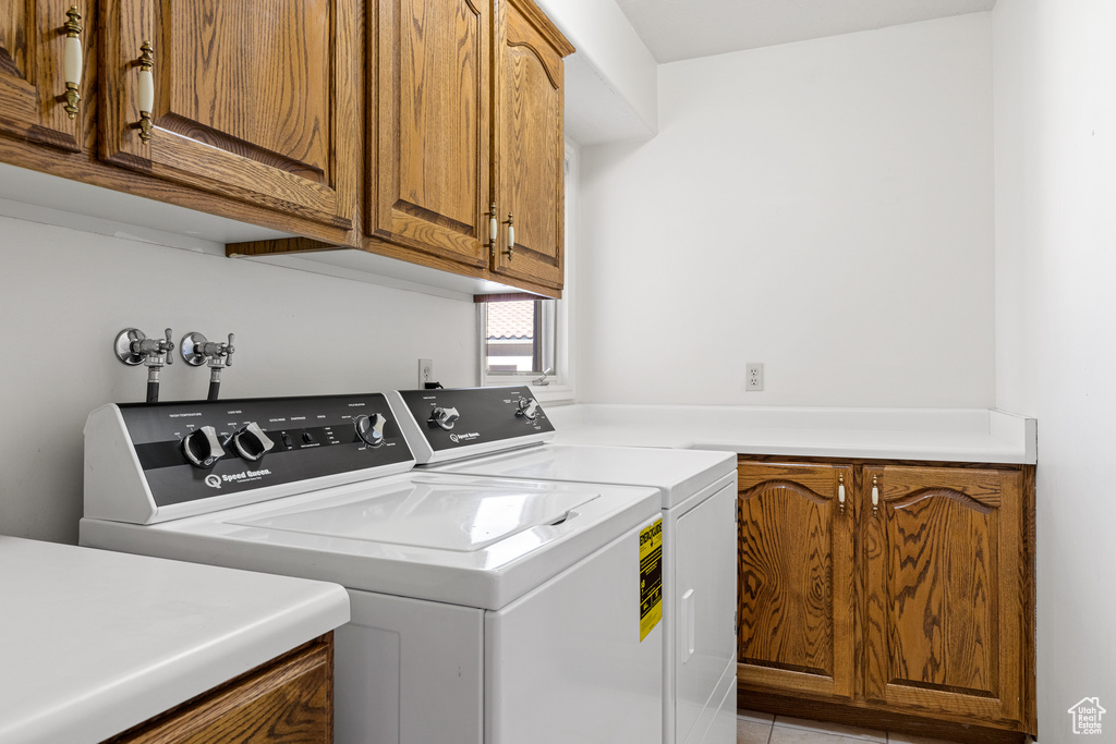 Washroom with cabinets, washer hookup, and washer and clothes dryer