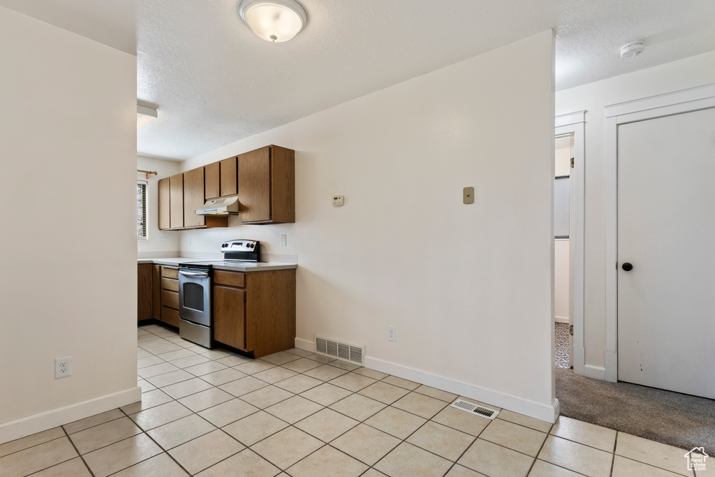 Kitchen featuring light tile flooring and electric range oven