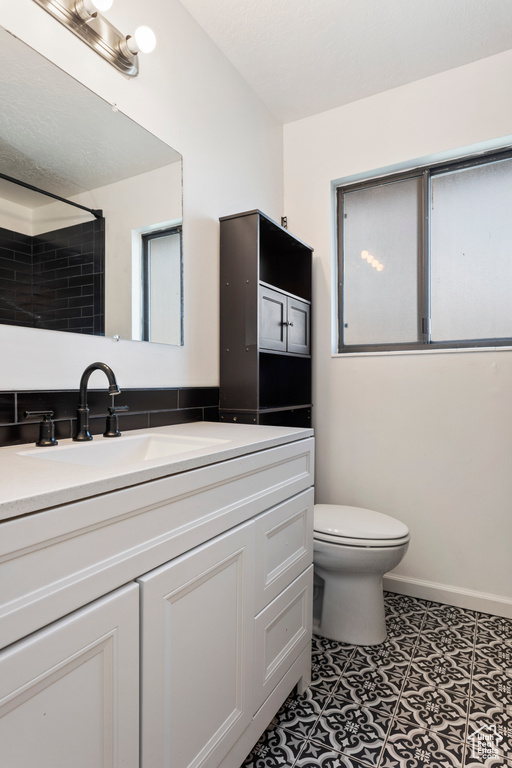 Bathroom featuring tile floors, toilet, and vanity with extensive cabinet space
