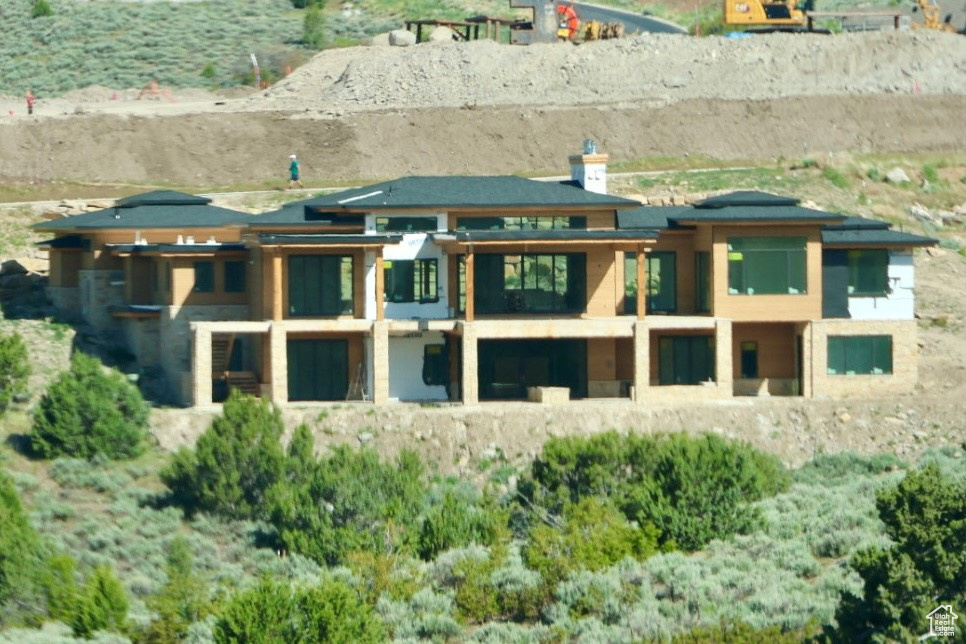 Back of property with a balcony and a chimney