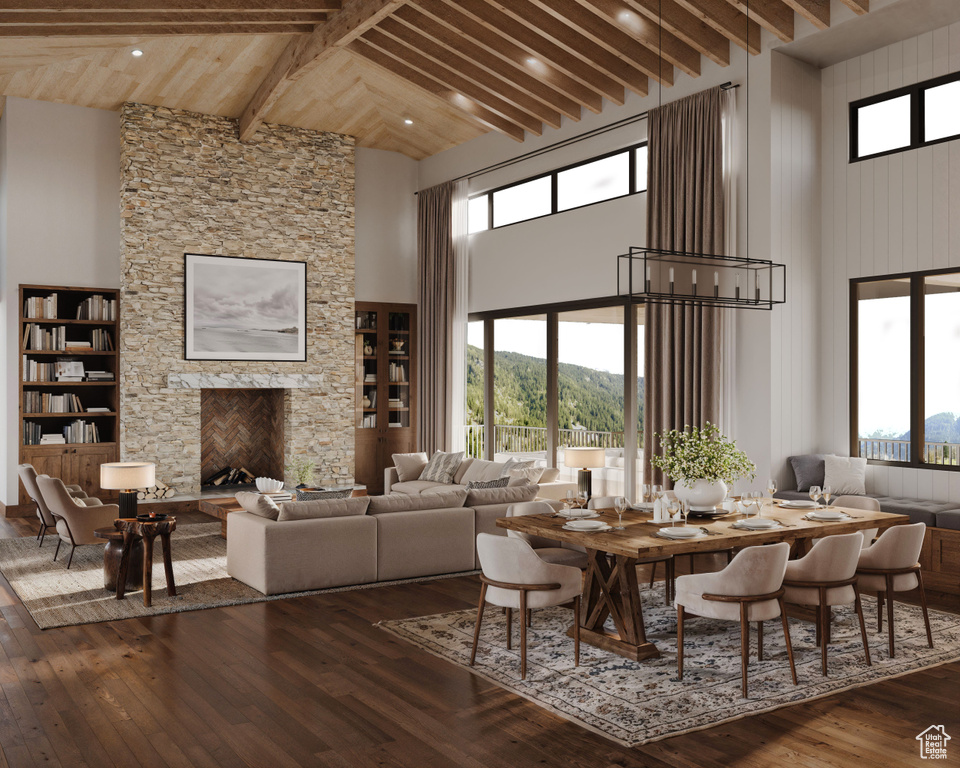 Dining area featuring a towering ceiling, a fireplace, hardwood / wood-style flooring, and beam ceiling