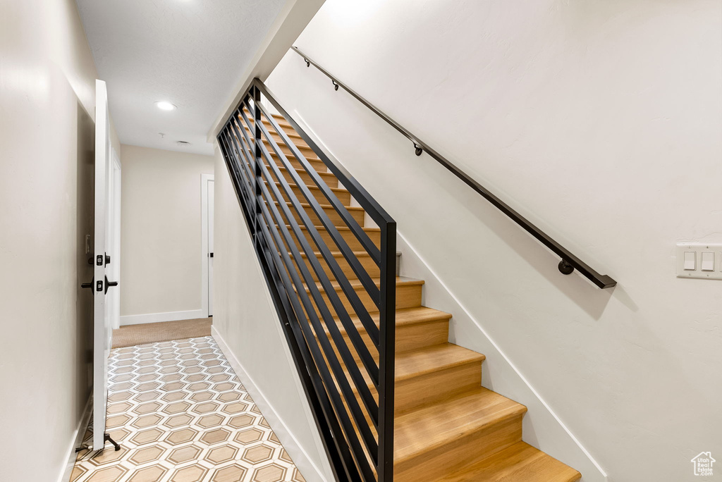 Staircase with light tile floors