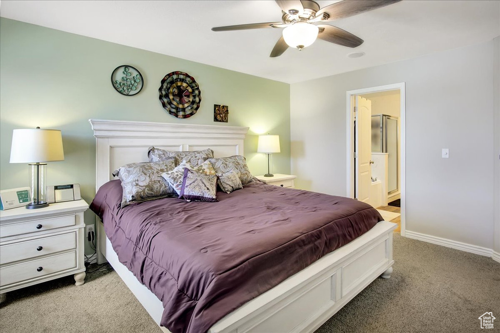 Carpeted bedroom with ceiling fan and ensuite bathroom