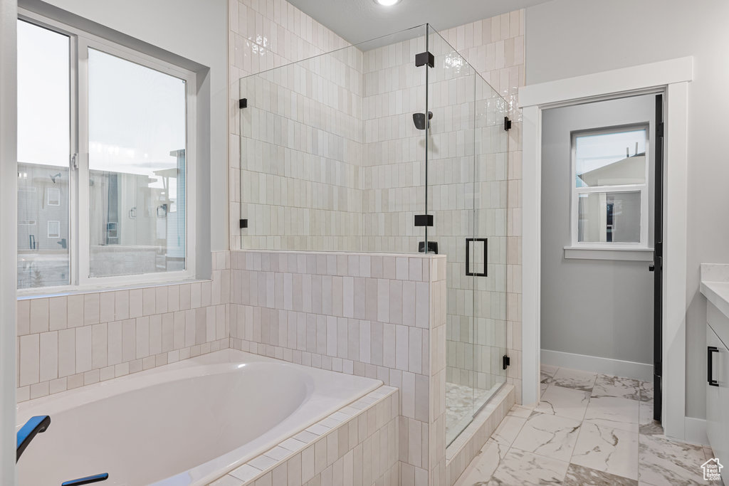 Bathroom featuring a healthy amount of sunlight, tile flooring, and independent shower and bath
