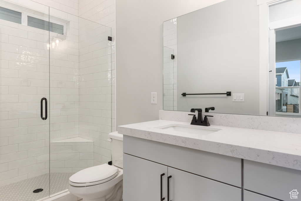 Bathroom with walk in shower, oversized vanity, and toilet