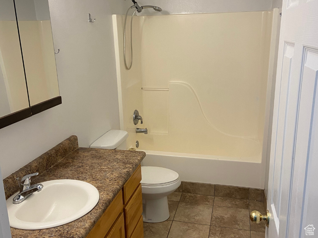 Full bathroom with tile flooring, toilet, tub / shower combination, and large vanity