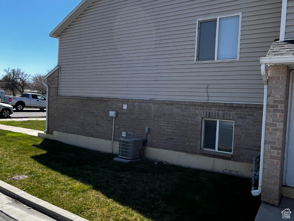 View of property exterior featuring a yard and central air condition unit