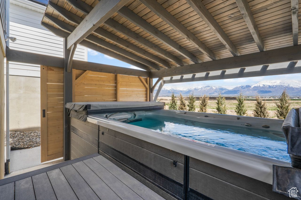 Exterior space with a hot tub and a mountain view