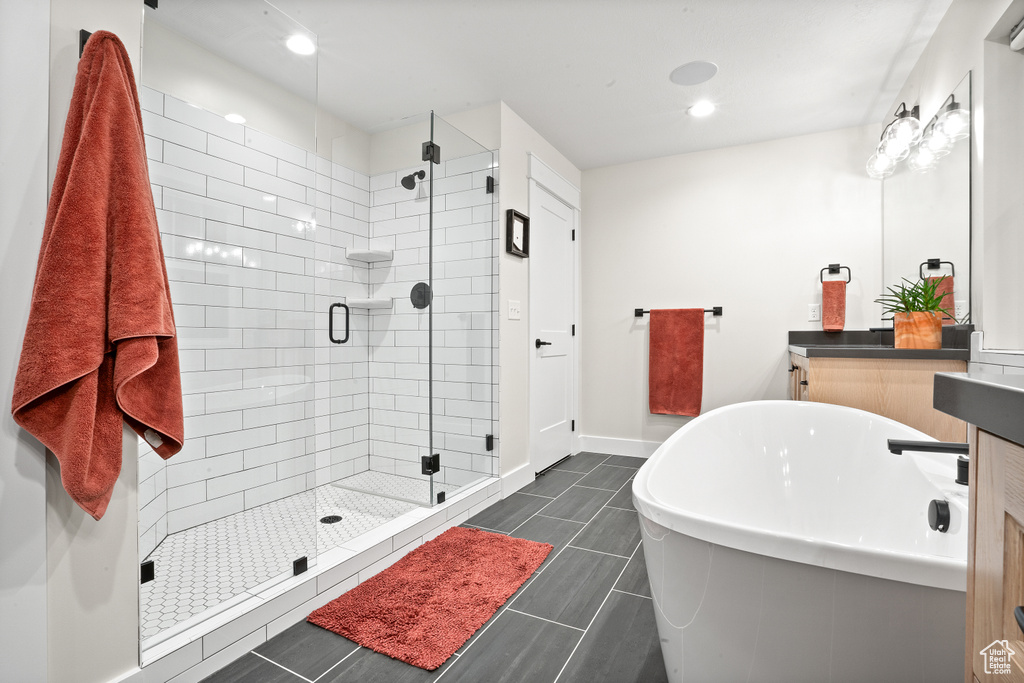 Bathroom with tile flooring, vanity, and plus walk in shower