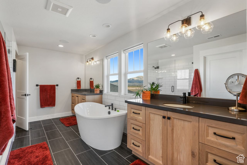 Bathroom featuring vanity, tile floors, and a washtub