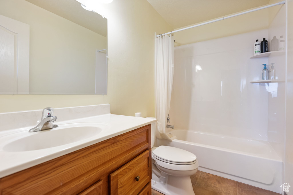 Full bathroom with tile flooring, vanity, shower / bath combination with curtain, and toilet